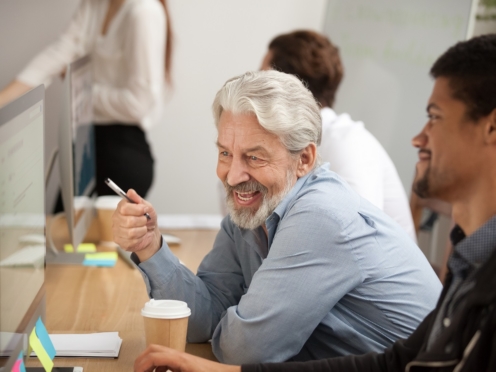 Mature male leader with colleague at computer