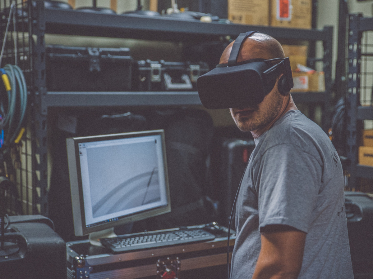Man in workshop with computer and visor automating